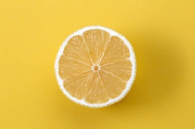 Sarı arkaplanda limon diliminin makro fotoğrafı.