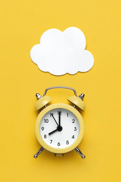 Sarı alarm saati ve sarı arkaplanda beyaz bulut.