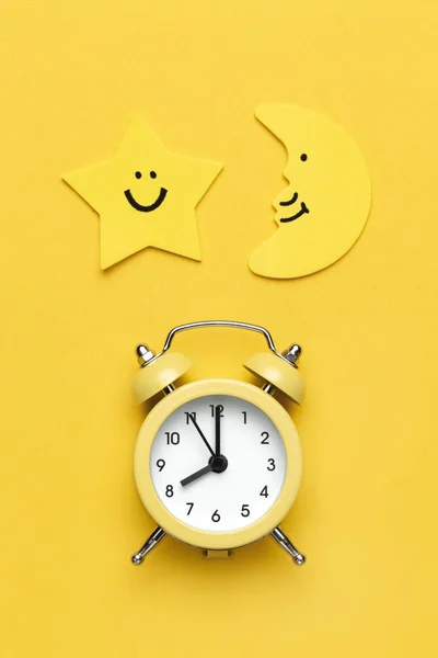黄色の丸い目覚まし時計、月と黄色の背景の星. — ストック写真