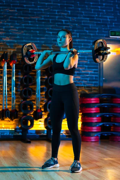 Mujer joven sana hacer ejercicios con barra de pesas en el gimnasio. Concepto Salud y Deporte . — Foto de Stock