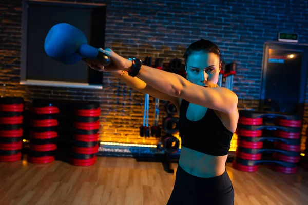 Foto de primer plano del entrenamiento de mujer joven en forma en el gimnasio con kettlebell . — Foto de Stock