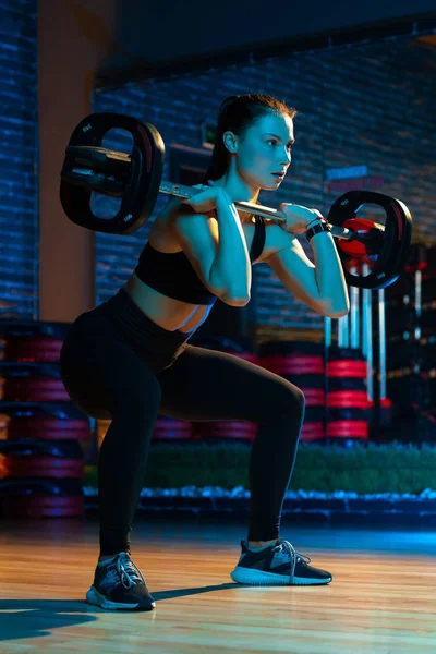 全长镜头的运动年轻女子做蹲式运动与杠铃在健身房。健康与体育概念. — 图库照片