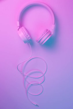 Beyaz kablosuz kulaklığın neon ışıklı Retro 90 tarzı fotoğrafı. Müzik konsepti.