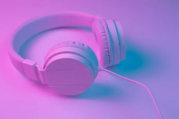 复古90年代风格的照片白色时尚无线耳机在霓虹灯。音乐概念. — 图库照片