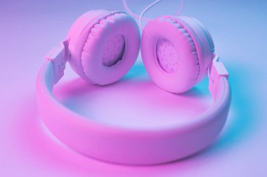 Beyaz kablosuz kulaklığın neon ışıklı Retro 90 tarzı fotoğrafı. Müzik konsepti.