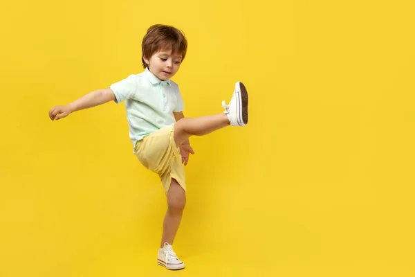 快乐有趣的孩子，听着音乐，在黄色的背景上跳舞. — 图库照片