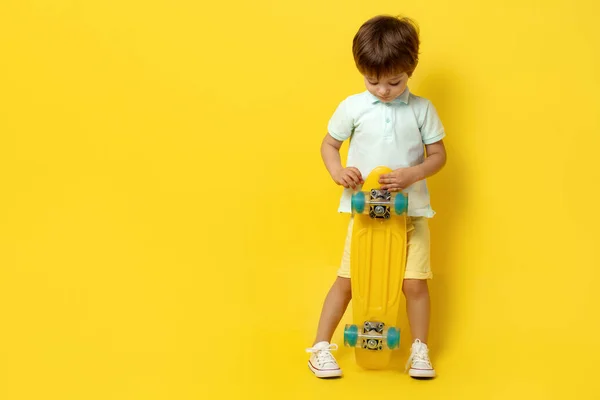 穿着休闲装、头戴黄底滑板或滑板的小男孩很可爱. — 图库照片