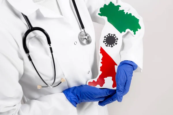 Médico o enfermero sosteniendo mapa y bandera de Italia. Brote de coronavirus y concepto pandémico. 2019-nCoV . —  Fotos de Stock