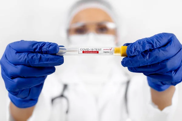Scientist doctor holding positive test tube sample for coronavirus. Coronavirus outbreak and pandemic concept.