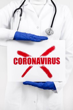 Üzerinde COVID 19 yazan afiş tutan doktor. Coronavirüs salgını ve salgın konsepti.
