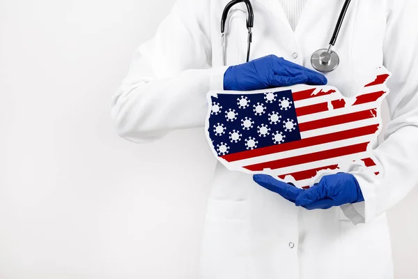 Amerikan haritası ve bayrağı taşıyan doktor ya da hemşire. Coronavirüs salgını ve salgın konsepti. 2019-nCoV.