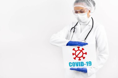 Elinde tabela olan kadın doktor COVID-19 'u beyaz fırının üstünde tutuyor. Coronavirüs salgını ve salgın konsepti.