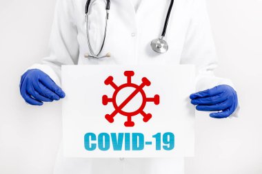 Üzerinde COVID 19 yazan afiş tutan doktor. Coronavirüs salgını ve salgın konsepti.