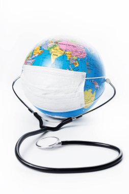 Beyaz arka planda antiviral cerrahi koruyucu yüz maskesi ve steteskobu olan dünya küresi. Gezegen konseptini koru.