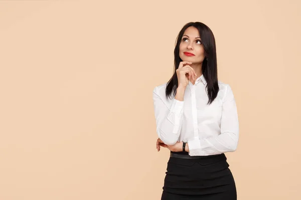 Confiado estratégico joven mujer de negocios moderna pensar mirando hacia arriba sobre fondo beige . —  Fotos de Stock