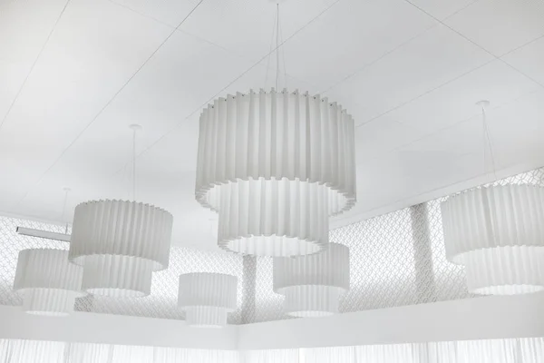 Photo of modern white ceiling light with circle shape. Minimalist interior design.