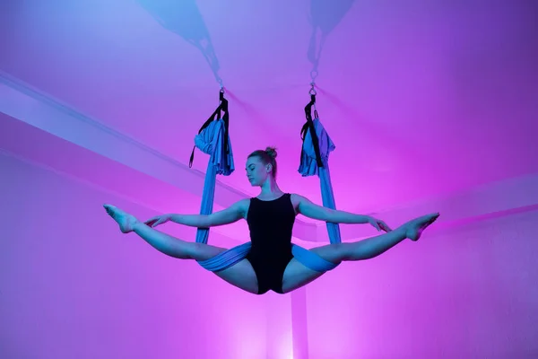 Ziemlich fitte junge Frau beim Fly Yoga Stretching mit Hängematte im Yogastudio. — Stockfoto