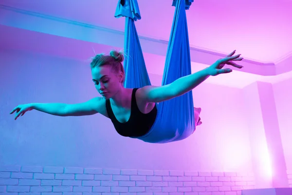 CHarming fit junge Frau beim fliegen Yoga Stretching mit Hängematte im Yoga-Studio. — Stockfoto