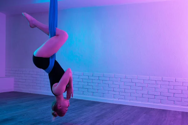 Fit junge Frau macht Gravitations-Luft-Yoga-Stretching-Übungen im Yoga-Kurs. Balance zwischen Körper und mentalem Konzept. — Stockfoto