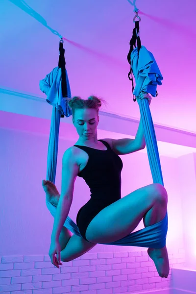 Fit junge Frau macht Gravitations-Luft-Yoga-Stretching-Übungen im Yoga-Kurs. Balance zwischen Körper und mentalem Konzept. — Stockfoto