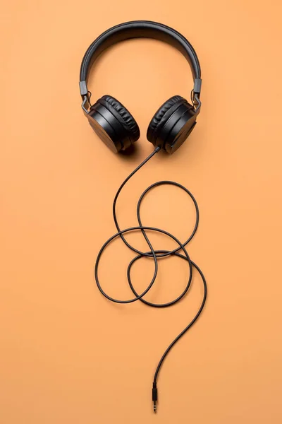 Foto de elegantes auriculares negros modernos sobre fondo beige . —  Fotos de Stock