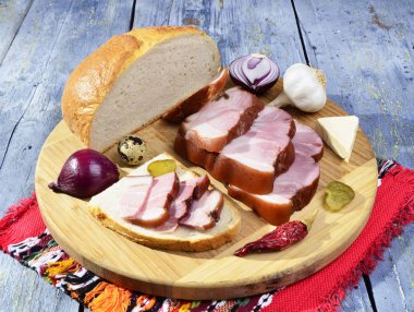 Füme pastırma, turşu, soğan, sarımsak, kırmızı biber ahşap bir masa - mavi antika arka plan üzerinde rustik tarzı üzerinde.