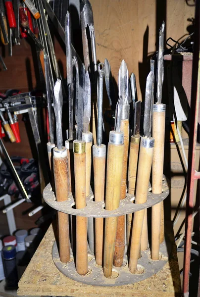 work table of a carpenter with many  tools olds hanging