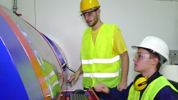 Jovens trabalhadores na sala de máquinas — Vídeo de Stock