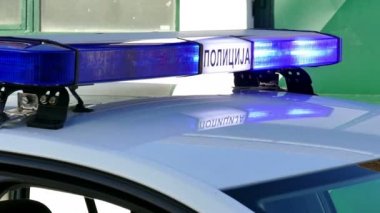 Polis arabası Strobe ışıklar yanıp sönen; Bir polis arabası trafik kaza mahallindeki mavi ışıkları yanıp sönüyor. Kiril yazıt