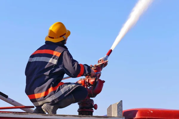 水大砲を持つ消防士消防士放水で消火 — ストック写真