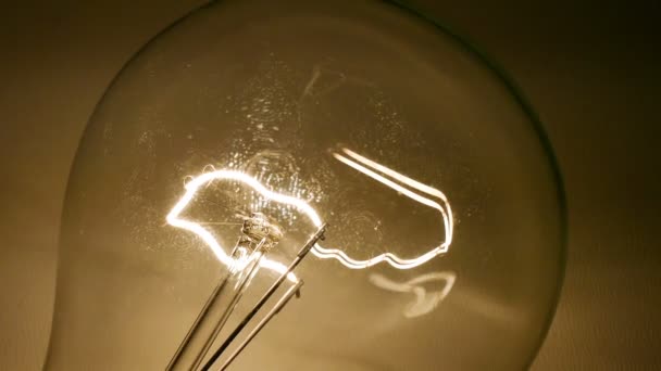 白熱電球タングステン 実際の電球がオンになって 暗い背景に輝きとちらつき — ストック動画