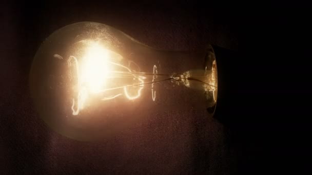 Ampoules éclairées / Ampoule réelle allumée, brillance et scintillement sur fond noir 