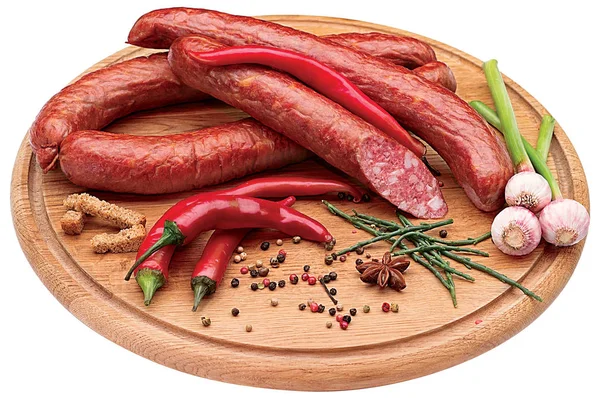 Копченые колбасы с острым перцем, луком и специями на доске — стоковое фото