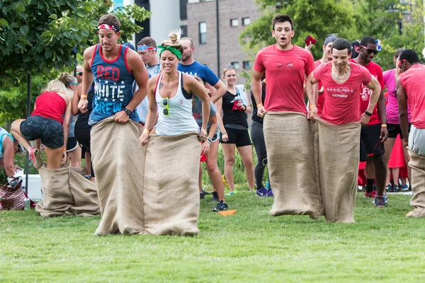 Adultos jóvenes participan en la carrera de sacos en el Atlanta Field Day — Foto de Stock