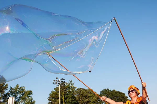 Frau macht mit Seifenwasser massive Blase auf Festival — Stockfoto