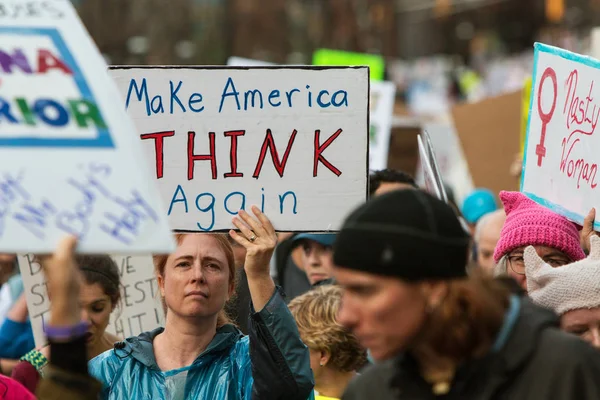 Frau hält Schild hoch, während Demonstranten auf dem Marsch sind — Stockfoto