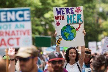 Woman Holds Up Sign Marching At Atlanta Earth Day March clipart