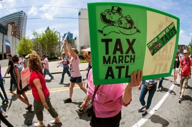 Woman Holds Sign In Atlanta Trump Tax Protest Rally clipart