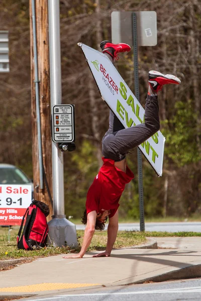 El hombre hace Cartwheel con la muestra para promover el acontecimiento que compra de la casa —  Fotos de Stock