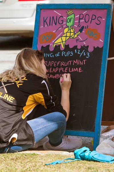 Adolescent écrit popsicle saveurs sur tableau avant événement au parc — Photo