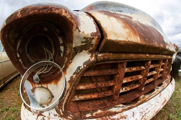 古い錆びたジャンク ヤードの車両から壊れたヘッドライトがハングアップします。 — ストック写真