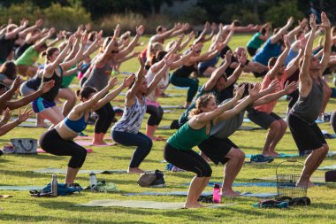 İnsanlar açık grup Yoga sınıf Utkatasana poz yapmak