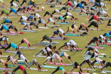 İnsanlar aşağı doğru bakan köpek poz grup Yoga sınıfındaki yapar