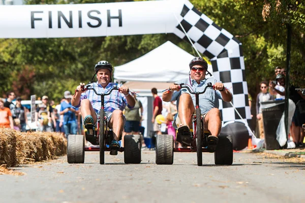 Dois homens montando adulto Big Wheels corrida em Atlanta Festival — Fotografia de Stock