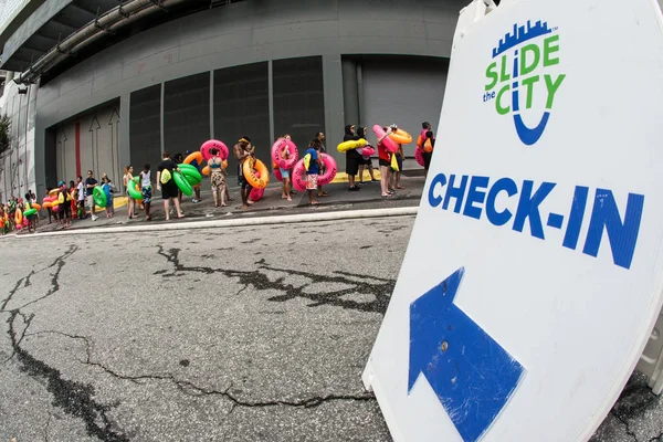 People Carrying Innertubes Wait In Long Line At Waterslide Event — Stock Photo, Image