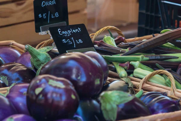 Los letreros de pizarra promueven la berenjena y la okra en el mercado local de agricultores — Foto de Stock