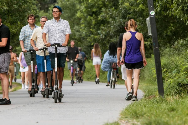 Young Men Ride Motorized Scooters Along Atlanta Beltline Path Stock Photo