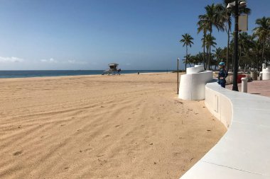 Fort Lauderdale, Florida / ABD - 21 Mayıs 2020: Maske takan yalnız bir kadın, Covid-19 salgını nedeniyle 21 Mayıs 2020 'de Fort Lauderdale, Florida' da kapalı kalan plajlara bakıyor..