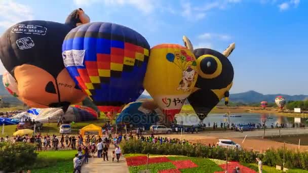 Chiang Rai, Tailândia - 17 de fevereiro de 2017: balões de ar quente de lapso de tempo inflam e muitos povos desfrutam no Singha Park International Balloon Fiesta 2017 (zoom out ) — Vídeo de Stock