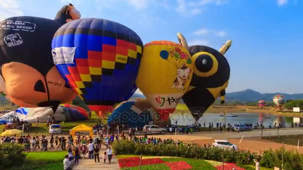 Chiang Rai, Tailândia - 17 de fevereiro de 2017: balões de ar quente de lapso de tempo inflam e muitos povos desfrutam no Singha Park International Balloon Fiesta 2017 (pan shot ) — Vídeo de Stock